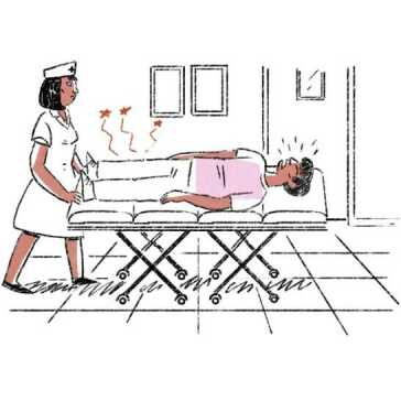 A nurse pushing a man on a trolley in a hospital.